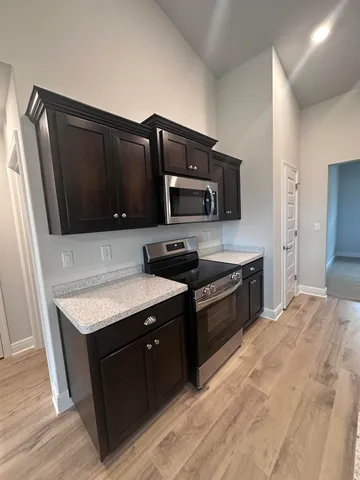 a kitchen with stainless steel appliances granite countertop a stove a microwave a sink and a refrigerator