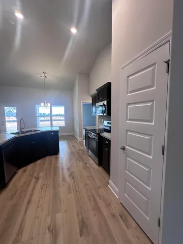 a kitchen with granite countertop a refrigerator and a stove top oven