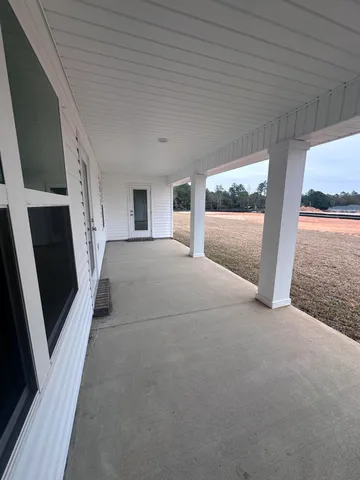 a view of a big room with wooden floor and windows