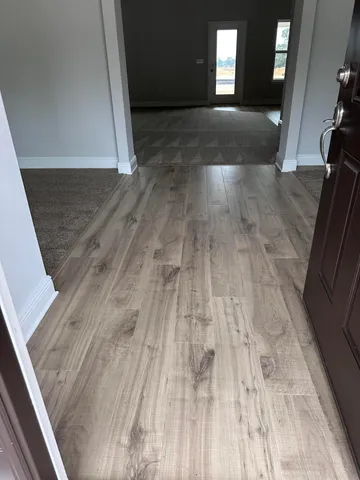 a view of a hallway with wooden floor