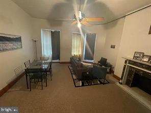 1115 North Calvert Street Baltimore, MD 21202 - Photo 31 of 35 a living room with furniture a dining table and a fireplace