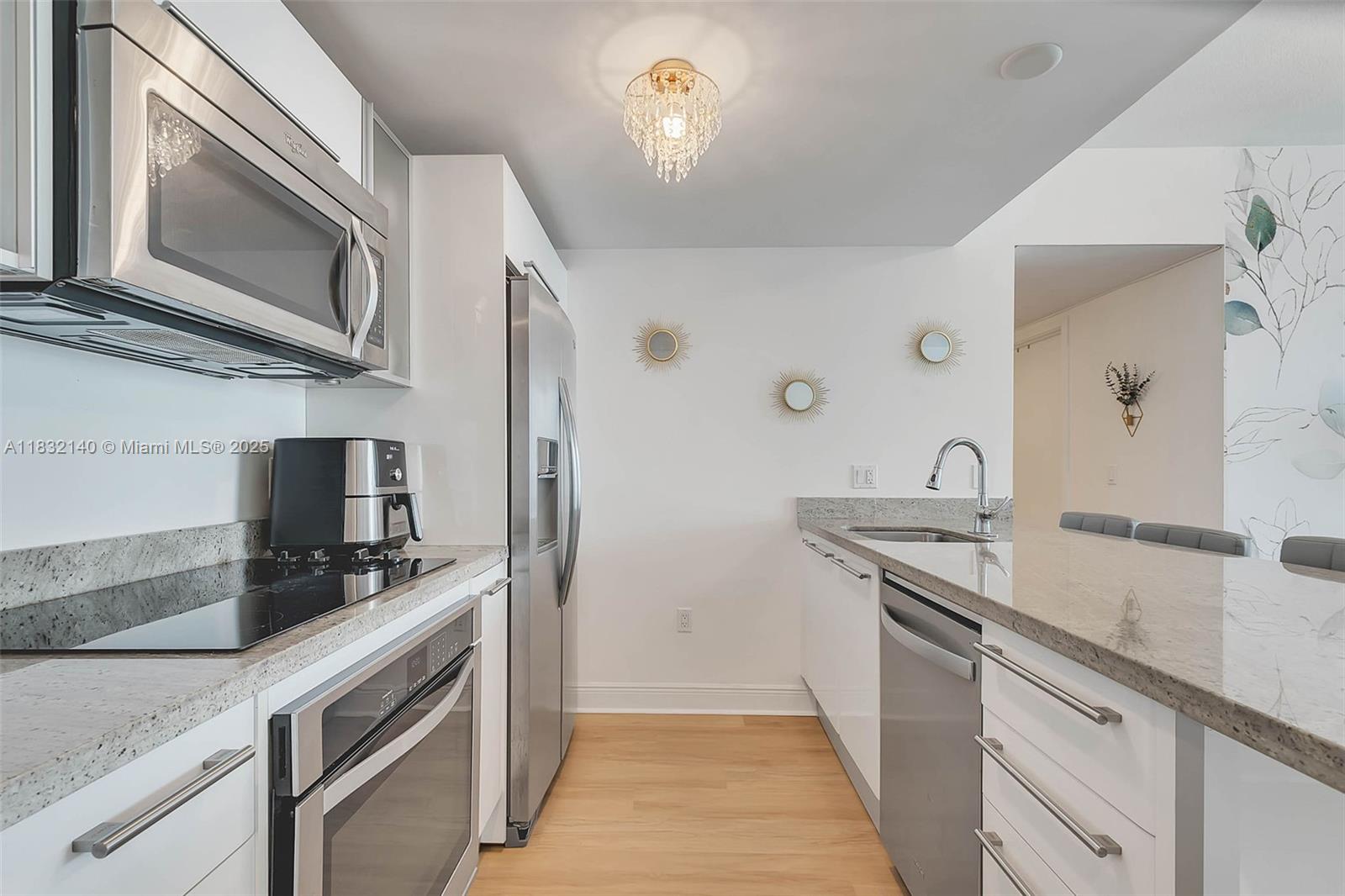 185 Southwest 7th Street, Unit 2204 Miami, FL 33130 - Photo 5 of 21 a kitchen with stainless steel appliances granite countertop a sink stove and microwave