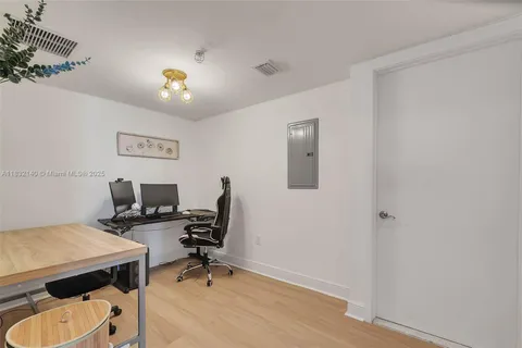 a view of a workspace with furniture and a window