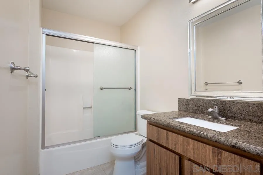 6046 Rancho Mission Road, Unit 384 San Diego, CA 92108 - Photo 12 of 18 a bathroom with a granite countertop sink toilet and shower