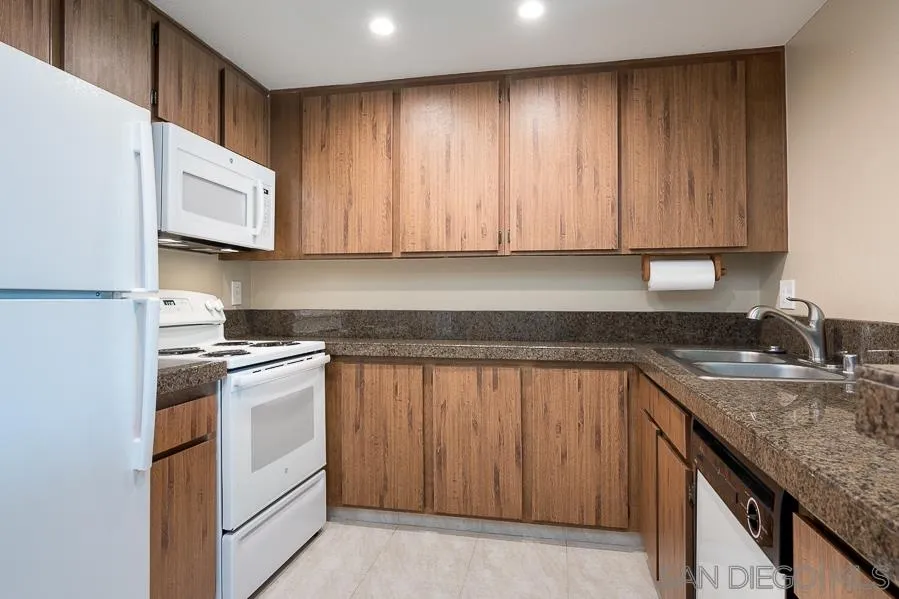 6046 Rancho Mission Road, Unit 384 San Diego, CA 92108 - Photo 8 of 18 a kitchen with a sink stove and cabinets