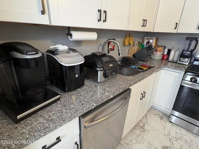 a kitchen with stainless steel appliances a stove a refrigerator and a microwave