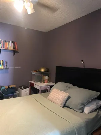 a bedroom with a bed and a lamp on dresser