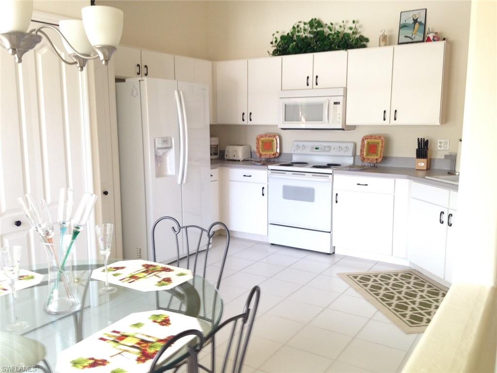 a kitchen with stainless steel appliances cabinets a table and chairs
