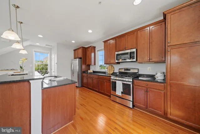 a kitchen with stainless steel appliances granite countertop a refrigerator stove a sink and a microwave