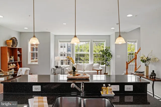 a kitchen with stainless steel appliances granite countertop a stove a refrigerator and a wooden floor