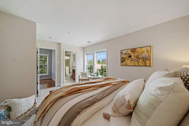 a bedroom with a bed and a lamp on dresser