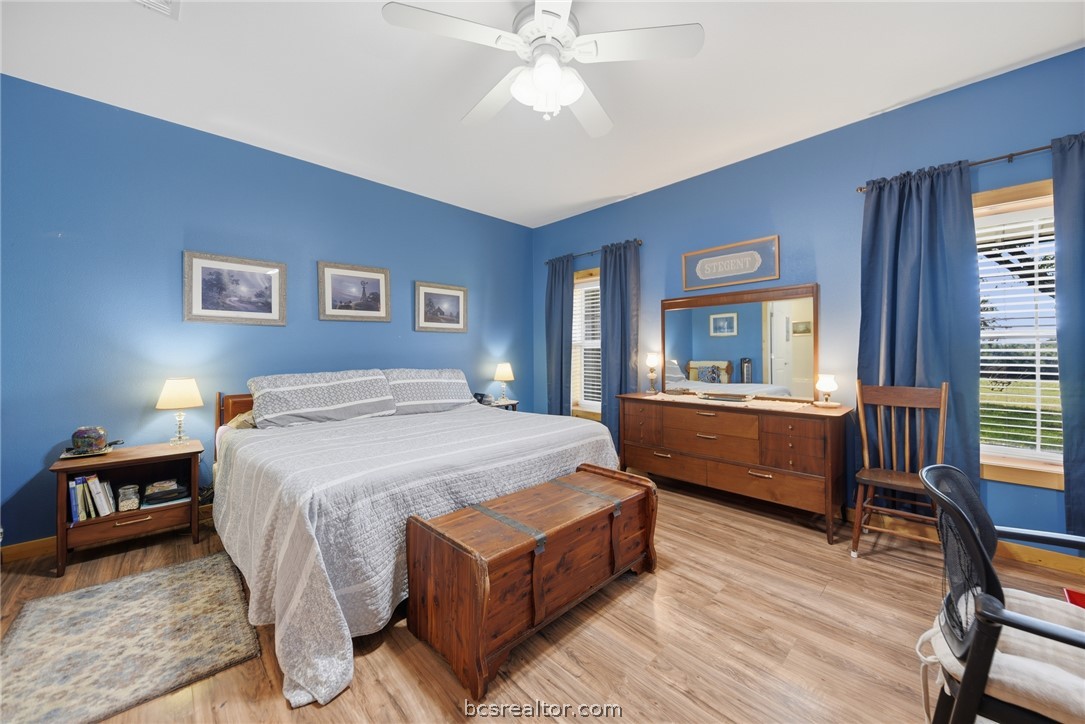 126 South Berlin Road Brenham, TX 77833 - Photo 14 of 30 a bedroom with a large bed a chandelier and windows