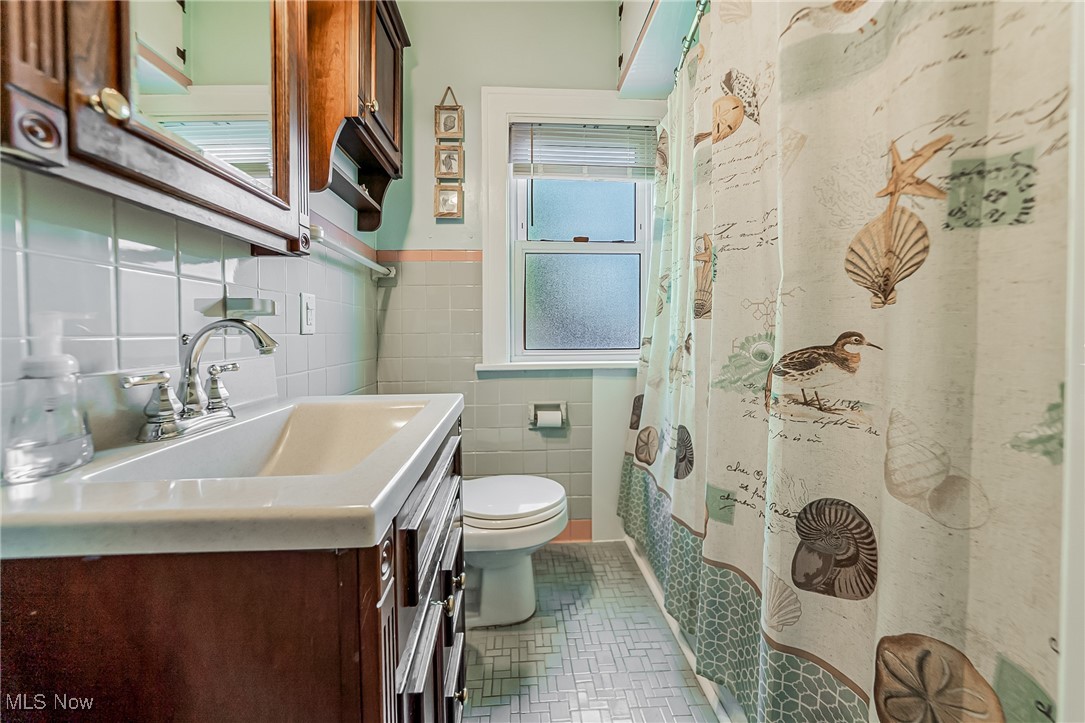 1104 Waverly Road Sandusky, OH 44870 - Photo 33 of 46 Bathroom featuring vanity, tile walls, tile patterned flooring, and a shower with shower curtain