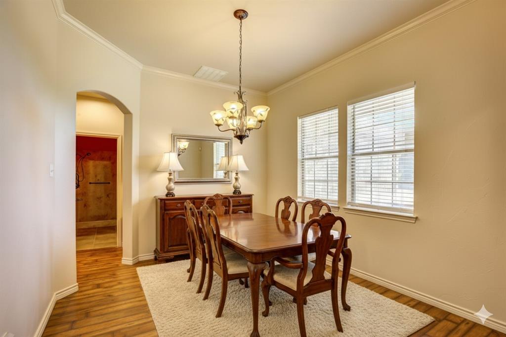 2617 Kirby Road Rowlett, TX 75088 - Photo 14 of 39 Virtually staged Dining area featuring ornamental molding, arched walkways, wood finished floors, and a chandelier