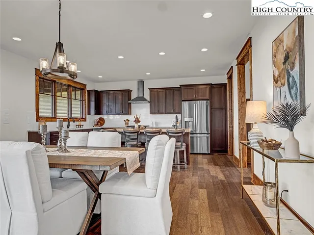 a living room with furniture a dining table and a chandelier