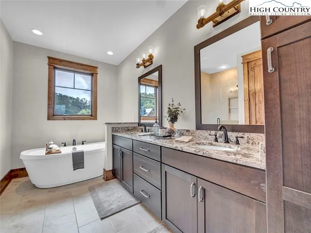 a bathroom with a granite countertop sink toilet mirror and bathtub