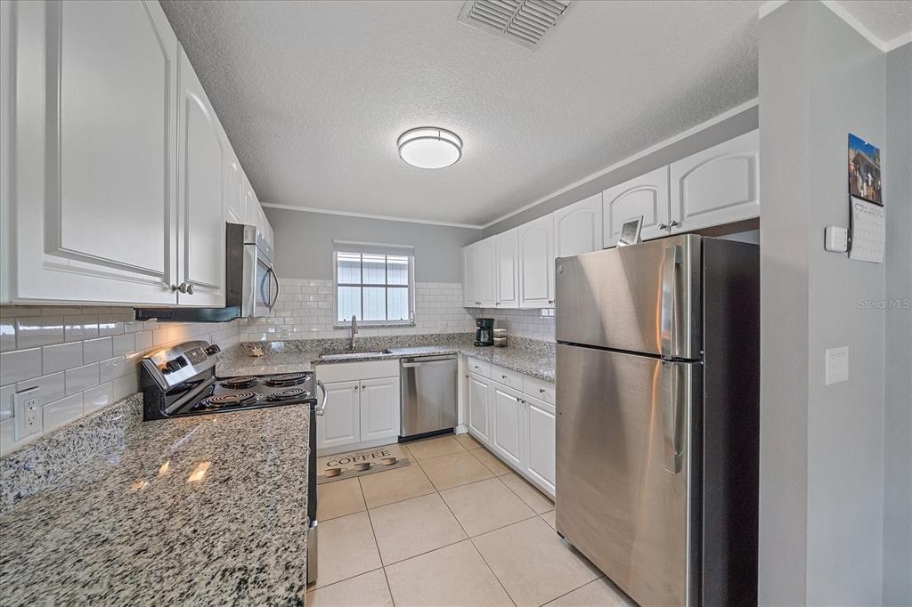 772 Locklear Avenue Sarasota, FL 34237 - Photo 25 of 40 a kitchen with a refrigerator a stove a sink a washer dryer and cabinets