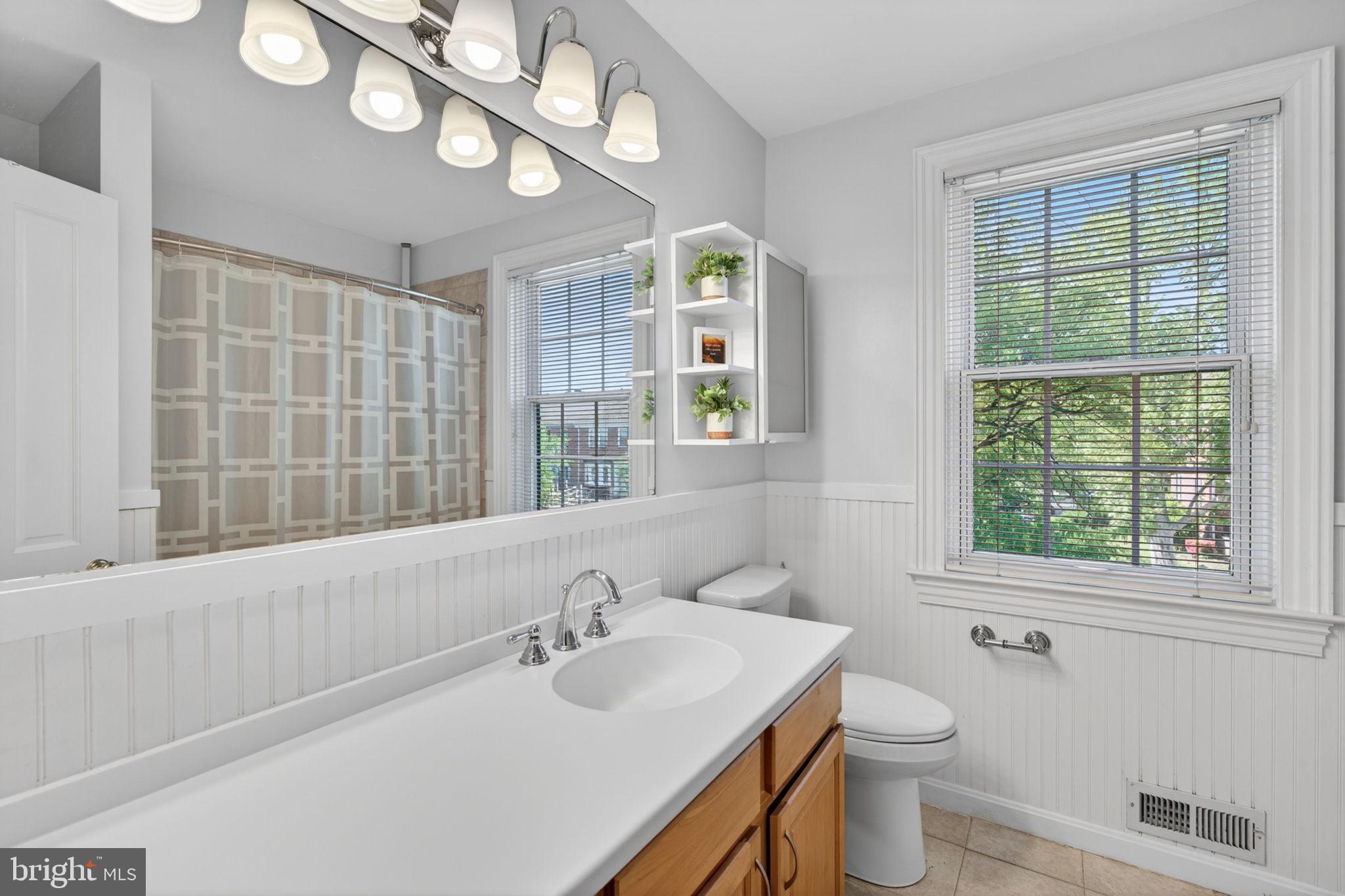 158 Hopkins Road Baltimore, MD 21212 - Photo 33 of 68 a bathroom with a sink a toilet and a large mirror