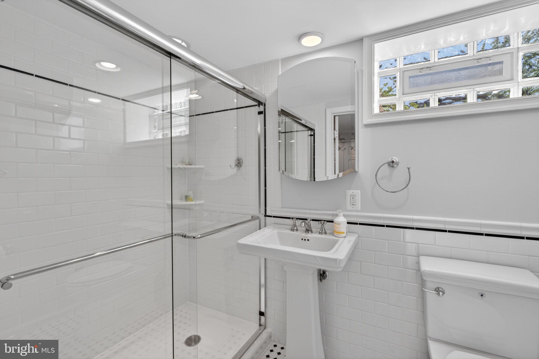 158 Hopkins Road Baltimore, MD 21212 - Photo 41 of 68 a bathroom with a sink a mirror and shower