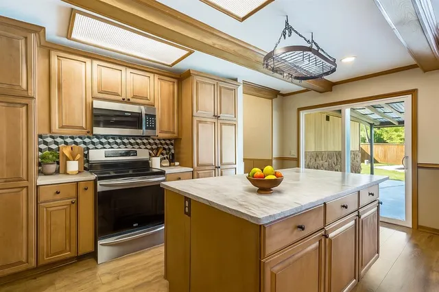 a kitchen with stainless steel appliances granite countertop a stove and a refrigerator