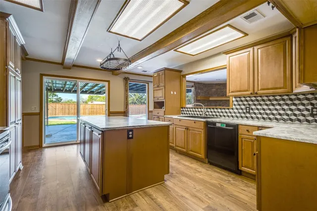 a kitchen with stainless steel appliances granite countertop a sink and wooden cabinets