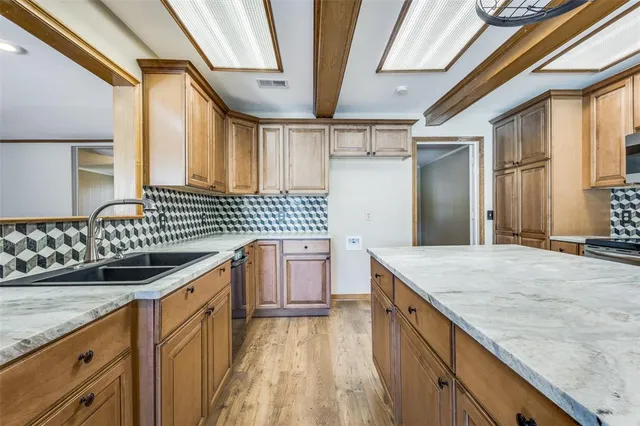 a kitchen with granite countertop a sink stove and cabinets