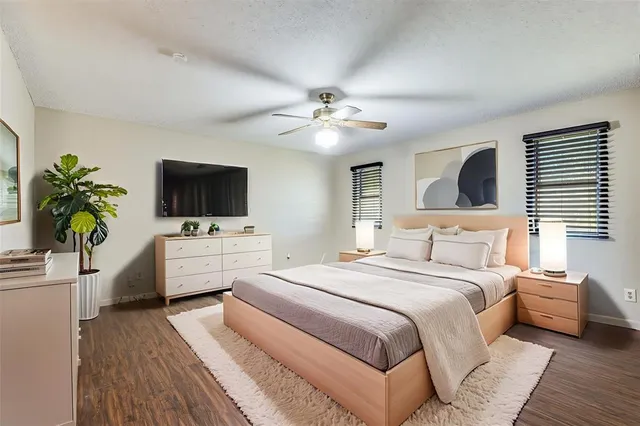 a bedroom with a bed a window and a flat screen television