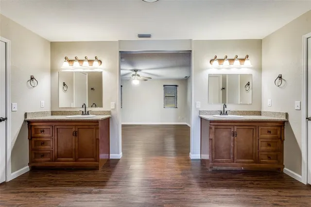 a spacious bathroom with a granite countertop sink a mirror and a vanity