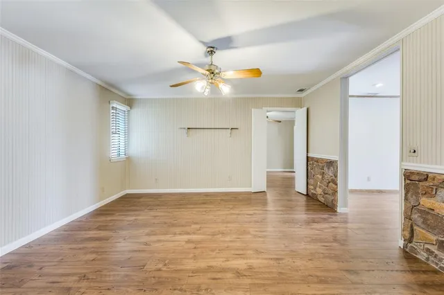 a view of an empty room with window and a ceiling fan