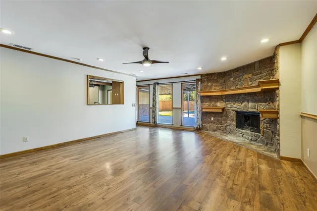 a view of an empty room with a fireplace and a window