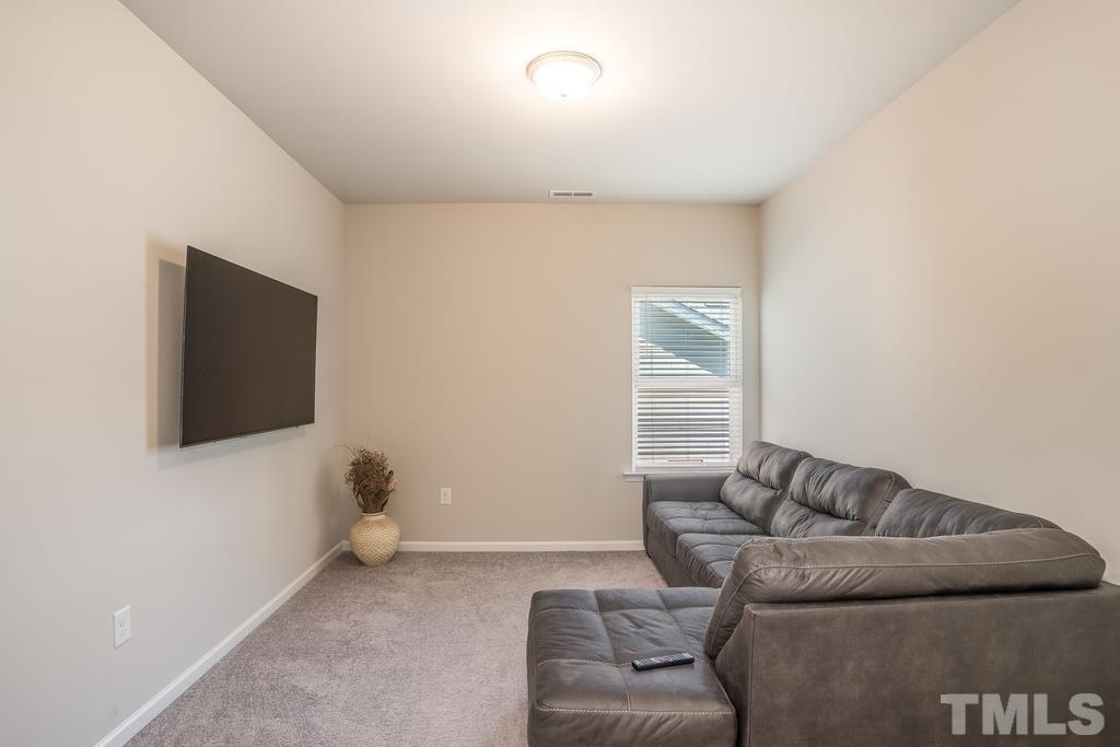 6801 Resting Grove Road Raleigh, NC 27610 - Photo 15 of 28 a living room with furniture and a flat screen tv