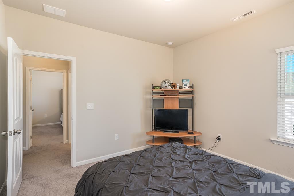 6801 Resting Grove Road Raleigh, NC 27610 - Photo 21 of 28 a view of a bedroom with a bed and a flat screen tv