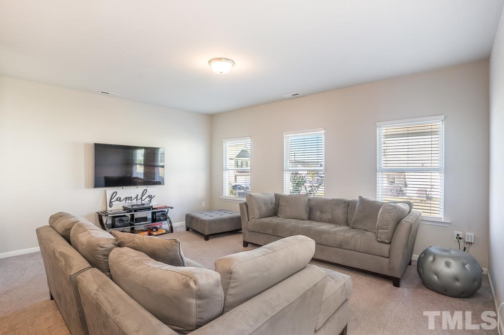6801 Resting Grove Road Raleigh, NC 27610 - Photo 8 of 28 a living room with furniture a flat screen tv and a window