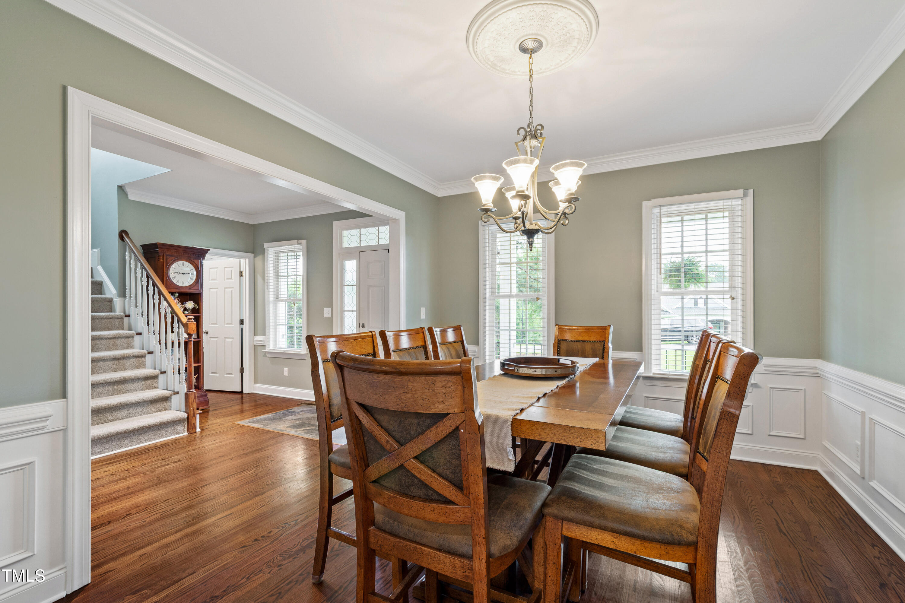 409 Broadmoor Way Clayton, NC 27520 - Photo 16 of 55 a dining room with furniture wooden floor a chandelier and a mirror