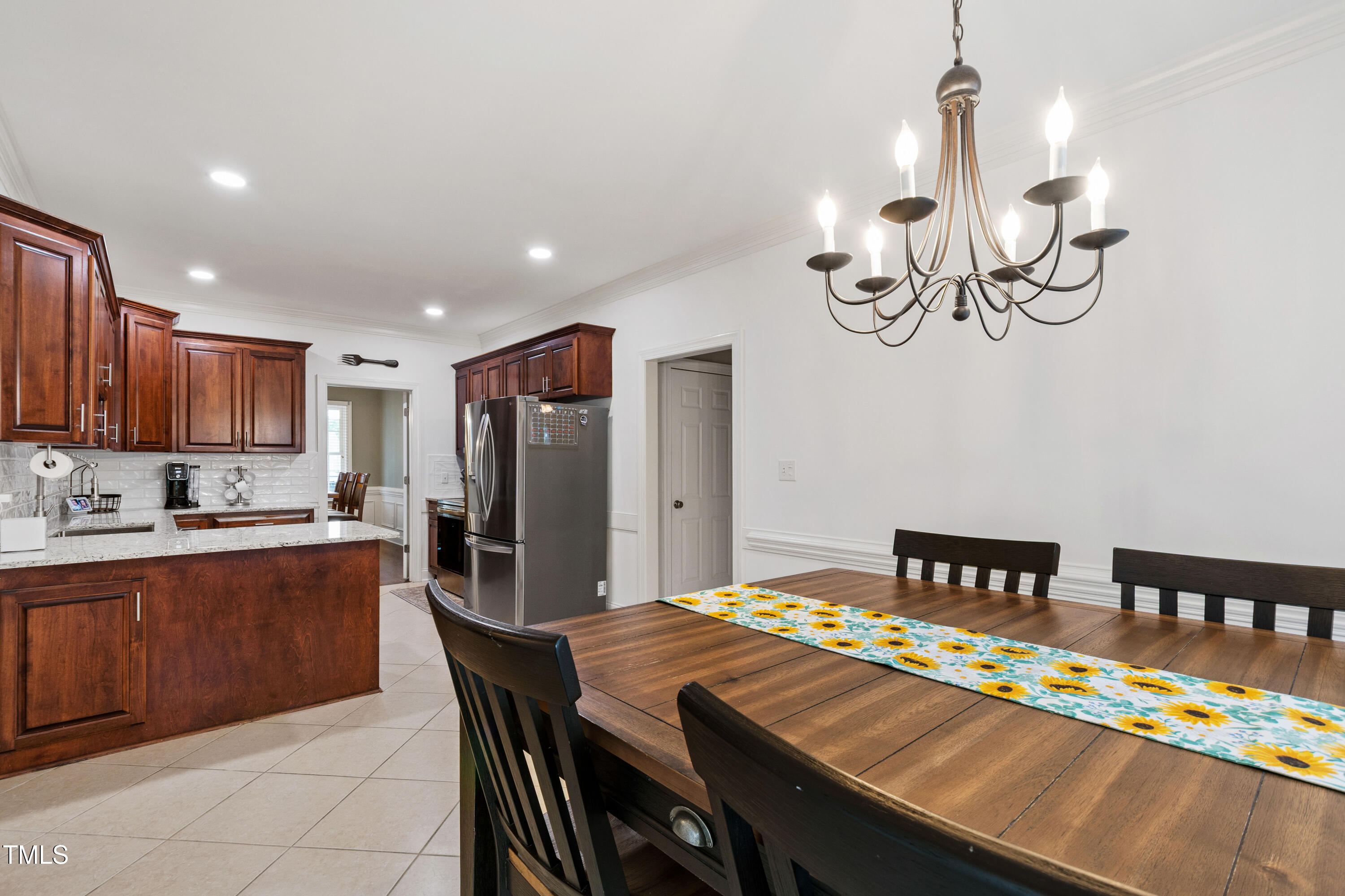 409 Broadmoor Way Clayton, NC 27520 - Photo 23 of 55 a kitchen with kitchen island a dining table and chairs