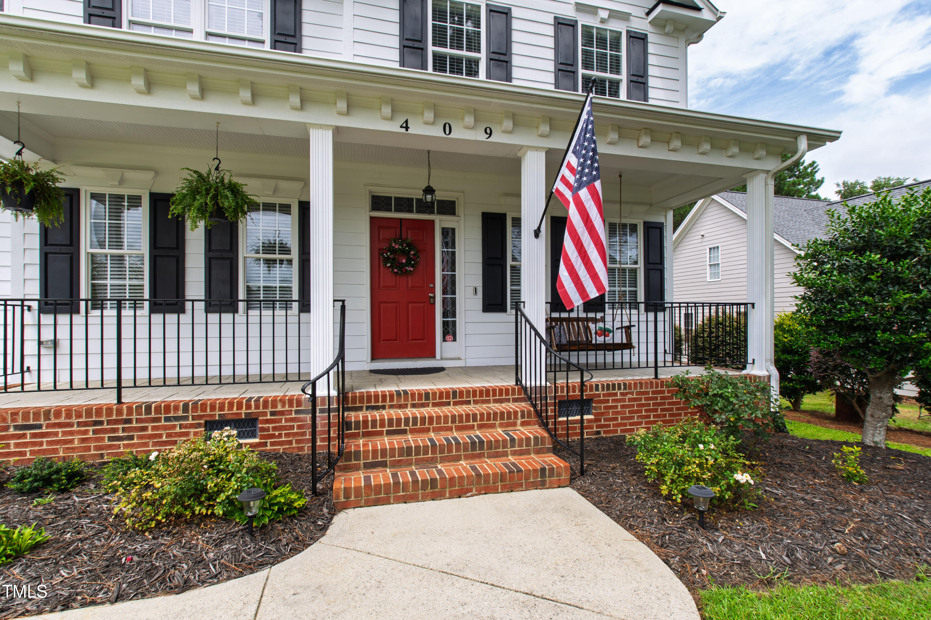 409 Broadmoor Way Clayton, NC 27520 - Photo 2 of 55 a view of a brick building with a large window and potted plants