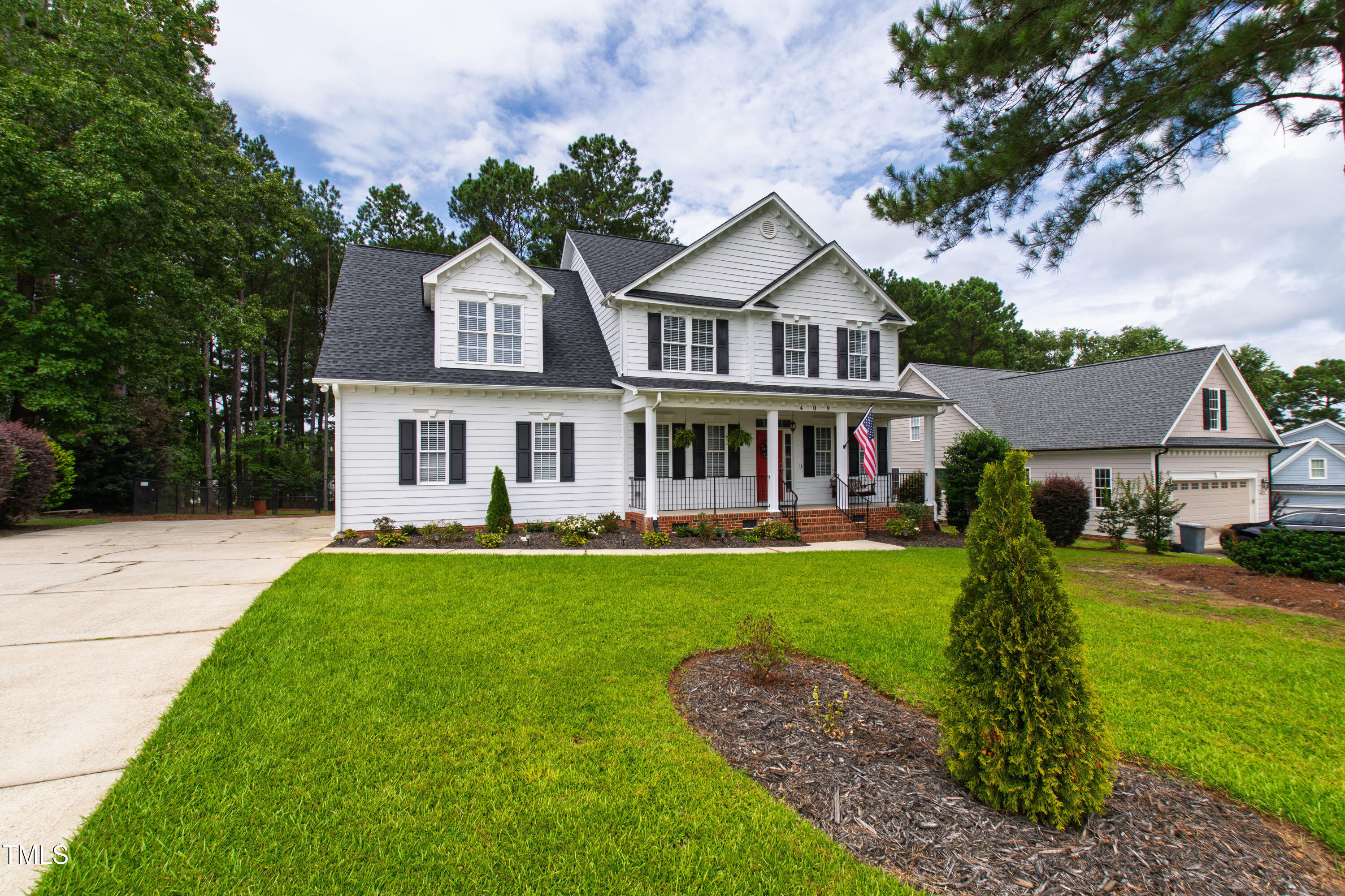 409 Broadmoor Way Clayton, NC 27520 - Photo 3 of 55 a front view of a house with a garden and trees