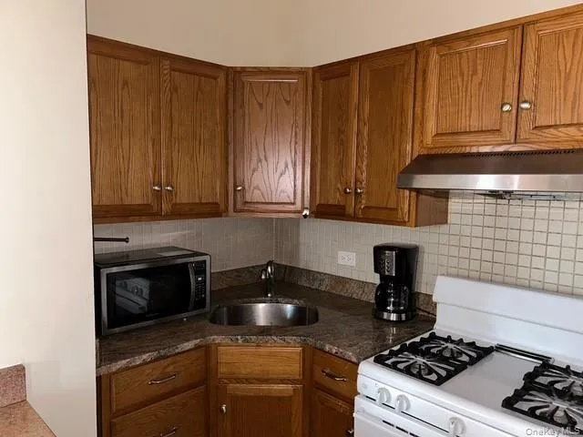 a kitchen with granite countertop a stove and a microwave
