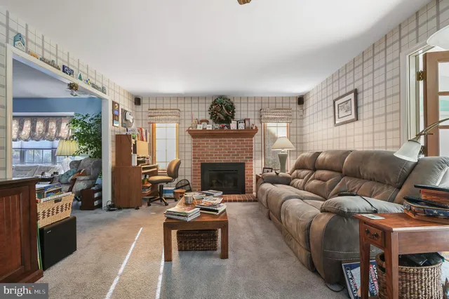 a living room with furniture a fireplace and next to a window