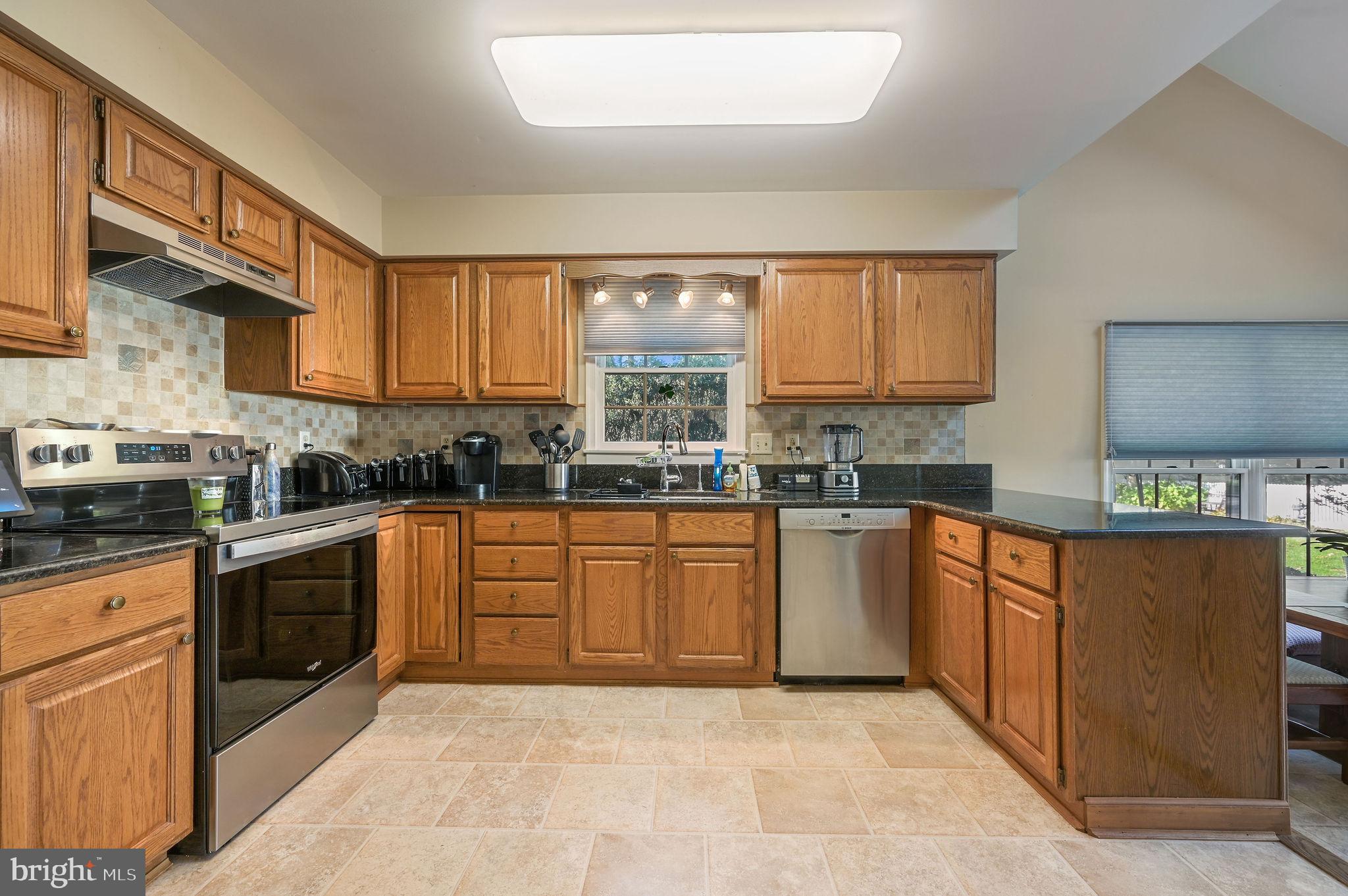 164 Burning Tree Road Dover, DE 19904 - Photo 22 of 37 a large kitchen with stainless steel appliances granite countertop a stove a sink and a refrigerator