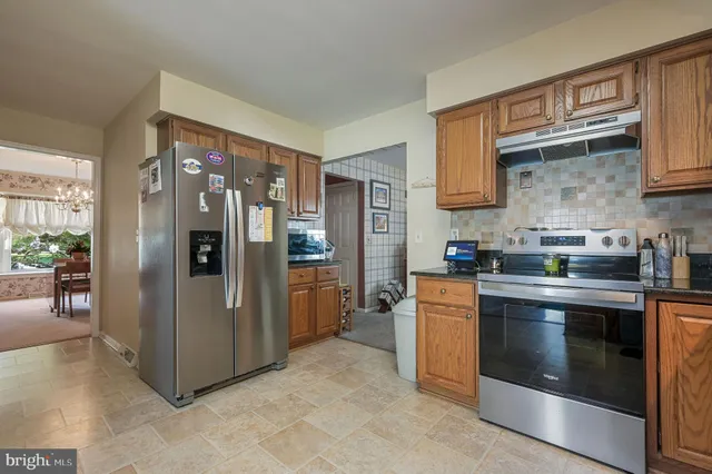 a kitchen with stainless steel appliances granite countertop a refrigerator and a stove top oven