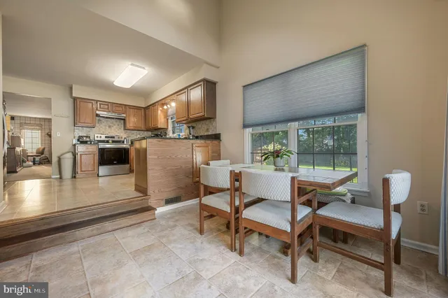 a dining room with furniture and a kitchen view
