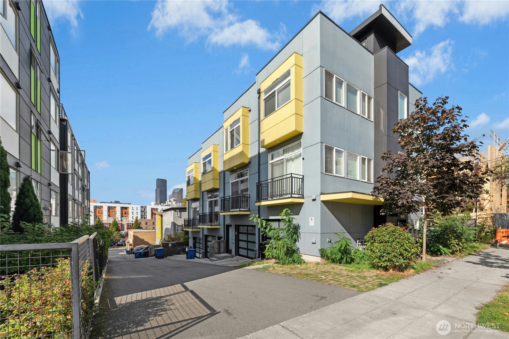 a front view of a building with garden and trees