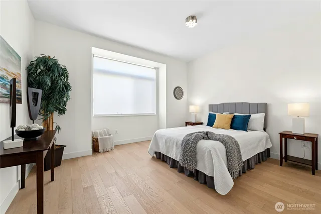 a spacious bedroom with a bed and a flat screen tv