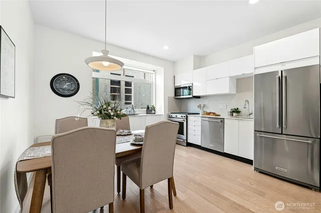 a kitchen with a refrigerator a stove top oven a clock and a window