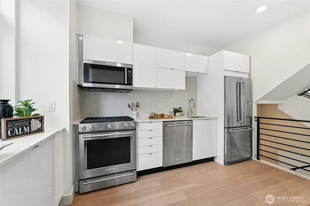 a kitchen with stainless steel appliances white cabinets and a stove top oven