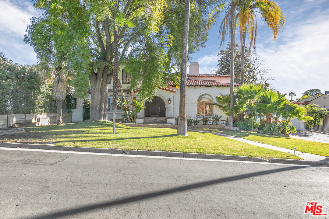 a view of a house with a swimming pool and a yard