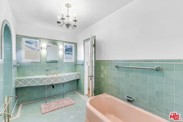 a large white bed in a large bedroom next to a window