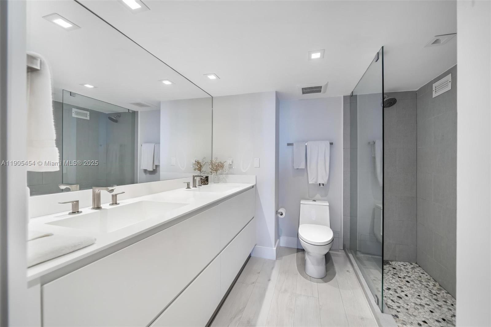 2301 Collins Avenue, Unit 1414/1415 Miami Beach, FL 33139 - Photo 11 of 40 a bathroom with a sink a toilet a shower and a mirror