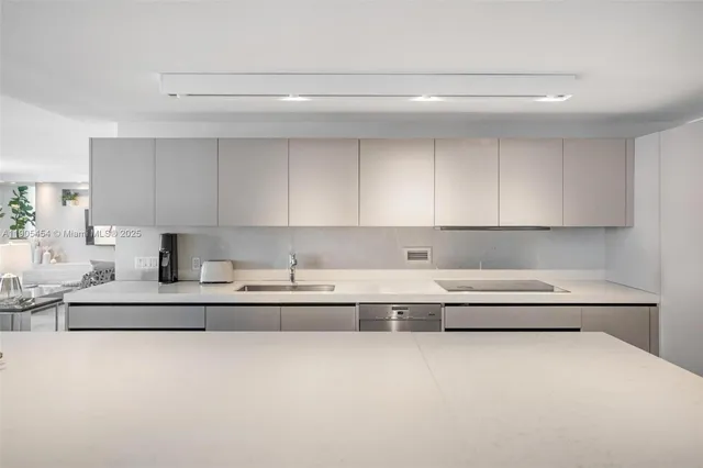 a large kitchen with a table chairs sink and cabinets